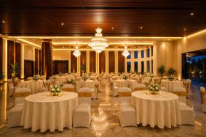 a large banquet hall with white tables and chairs at Ananta Express Jaunpur in Jaunpur
