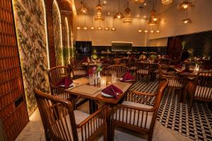 a restaurant with a table and chairs in a room at Ananta Express Jaunpur in Jaunpur +3 photos