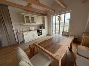 a large kitchen with a wooden table and a dining room at Villa Residenz am Vulkanradweg in Grebenhain