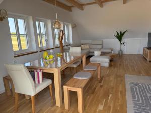 a living room with a dining room table and a couch at Villa Residenz am Vulkanradweg in Grebenhain +9 photos