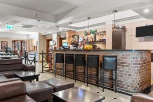a bar in a restaurant with brown leather seats at Hotel Diament Vacanza Katowice - Siemianowice in Siemianowice Śląskie