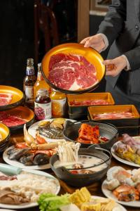 a person holding a plate of food on a table at Garden Hotel Suzhou in Suzhou
