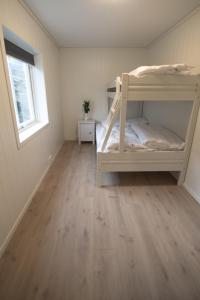 a bedroom with two bunk beds and a wooden floor at Lofthus Camping in Lofthus