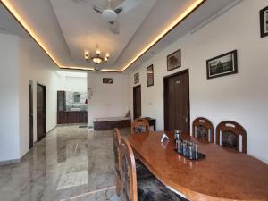 a dining room with a wooden table and chairs at Rayta Aravalli View Villa in Udaipur