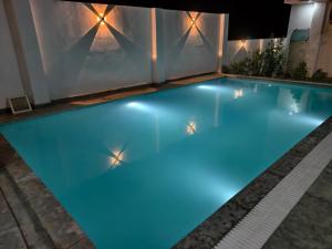 an indoor swimming pool with blue water at night at Rayta Aravalli View Villa in Udaipur +17 photos