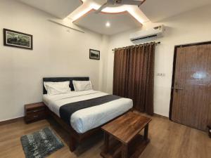 a bedroom with a bed and a table and a window at Rayta Aravalli View Villa in Udaipur