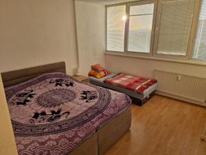 a bedroom with two beds and a couch in it at LV Central Apartment in Levice +3 photos