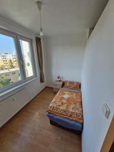 a small bedroom with a bed and a window at LV Central Apartment in Levice