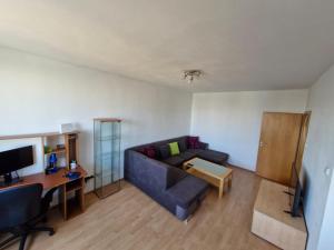 a living room with a couch and a desk at LV Central Apartment in Levice