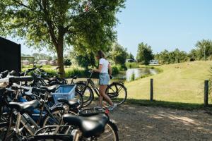 a woman standing next to a bunch of bikes at Resort Land & Zee in Scharendijke