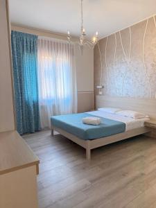 a bedroom with a bed with blue sheets and a window at Mar ricco Room 5 in Chioggia