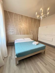 a small bedroom with a bed and a chandelier at Mar ricco Room 5 in Chioggia +3 photos