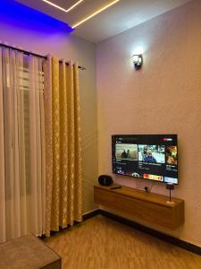 a living room with a flat screen tv on a wall at Vn mbeya apartment in Mbeya