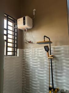a bathroom with a shower with a blow dryer on the wall at Vn mbeya apartment in Mbeya +21 photos