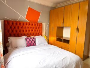 a bedroom with a large bed with an orange headboard at Immeuble paco in Douala