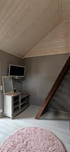 a room with a tv and a table with a couch at Raju - Guest House in Seinäjoki