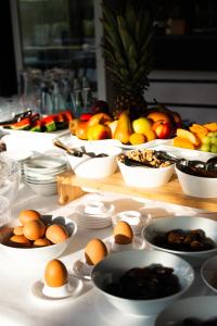 a table with plates of eggs and bowls of fruit at Hotel De Nac in Nago-Torbole
