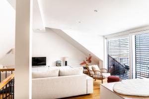 a white living room with a white couch at VINCENT Loft in der Innenstadt - mit Garage in Bregenz