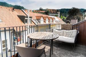 a wooden deck with a table and chairs on a balcony at VINCENT Loft in der Innenstadt - mit Garage in Bregenz