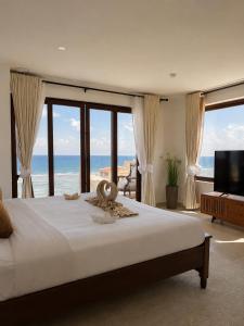 a bedroom with a bed with a view of the ocean at Sandy Shore Beach Apartments - Karibu Quarters in Kikambala +161 photos