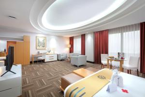 a hotel suite with a living room and a dining room at Merlynn Park Hotel in Jakarta