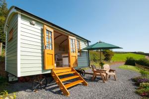 a tiny house with a bench and an umbrella at 1 Bed in Cove oc-cloudm in Bampton +6 photos