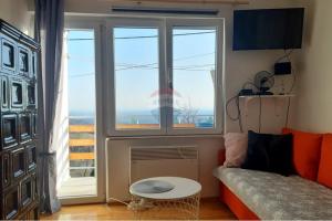 a living room with a couch and a large window at Holiday Home Nature Plesivica in Jastrebarsko