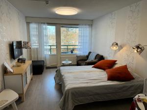a bedroom with a bed and a living room at Kylpylä-Hotelli 345 in Ikaalinen
