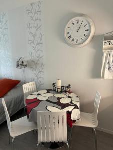 a dining room with a table and a clock on the wall at Kylpylä-Hotelli 345 in Ikaalinen
