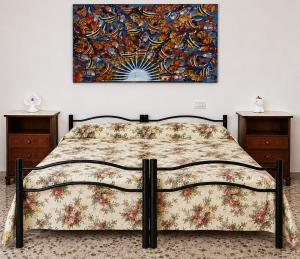 a bed in a bedroom with a painting on the wall at Casa Mare con finestra su balcone in Polignano a Mare