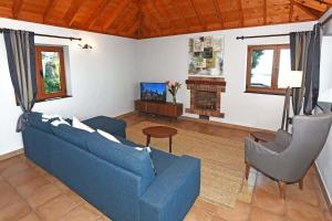 a living room with a blue couch and a tv at Casa Vista Mar in Tijarafe
