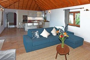 a living room with a blue couch and a kitchen at Casa Vista Mar in Tijarafe
