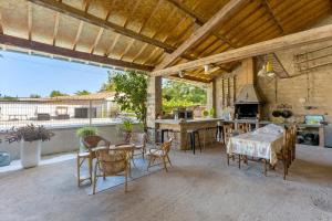 a patio with a table and chairs and a kitchen at Chambres D'hôtes Le Cocon in Saint-Paul-les-Fonts