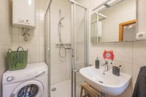 a bathroom with a washing machine and a sink at Ferienwohnung Emily in Garz +25 photos