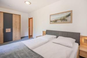 a bedroom with a large bed with white sheets at Ferienwohnung Emily in Garz