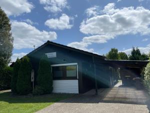 a blue building with a white garage at Haselbusch - Lastering Ferienhäuser & Apartments in Wettringen