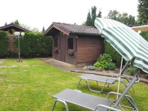 a garden with a picnic table and an umbrella at Haselbusch - Lastering Ferienhäuser & Apartments in Wettringen +3 photos