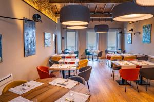 a restaurant with wooden tables and chairs and windows at Locanda Moderna Carlambroeus in Montevecchia