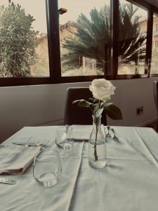 a white rose in a glass vase on a table at Hotel De Nac in Nago-Torbole