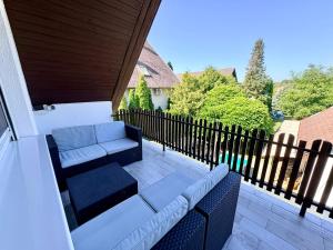 a patio with a couch and a fence at Oli vendégház in Balatonboglár +11 photos