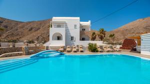 a swimming pool in front of a villa at Noème Santorini in Perissa