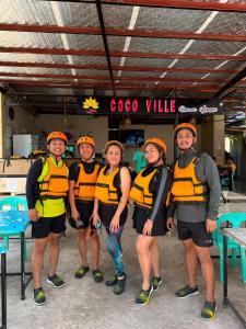 a group of people wearing life jackets and orange helmets at CocoVille Guesthouse Couple Room in Alegria