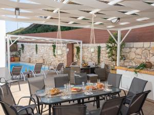a patio with a table and chairs and a pool at Sea Memories Villa in Skaleta