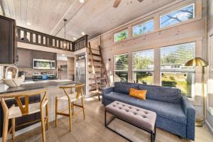 a living room with a blue couch and a kitchen at Asheville River Cabins, WorldHotels Backdrop in Arden