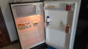 an open refrigerator with its door open and food inside at Samati Best House - Pool Apartments A1 - Klong Ning Beach in Ko Lanta Yai