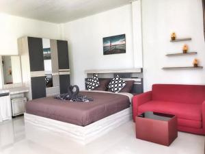 a living room with a couch and a red chair at Samati Best House - Pool Apartments A1 - Klong Ning Beach in Ko Lanta Yai