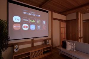 a large screen in a living room with a tv at 刀都の郷 清川 in Sekimachi +63 photos