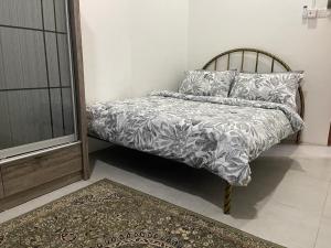 a bed in a room with a rug and a bed with a bedspread at RUANG by ZD in Pekan