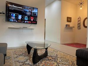 a living room with a glass table and a flat screen tv at RUANG by ZD in Pekan