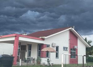 a white and red house with an umbrella at RUANG by ZD in Pekan